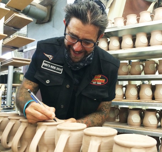 Riki Rachtman signing the bottom of the mugs